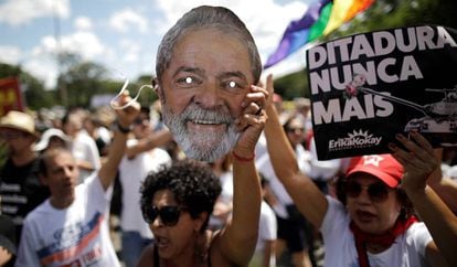 Mulher mostra máscara do ex-presidente Lula durante ato contra golpe de 64.