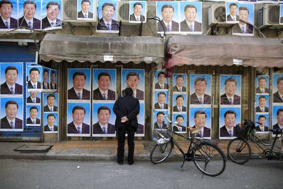 Transeunte observa cartazes com a imagem do presidente Xi Jinping, em Xangai.