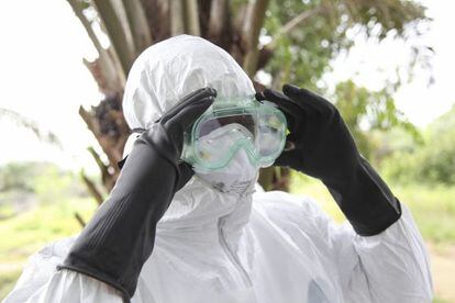 Um enfermeiro se protege para transportar uma vítima do ebola na Libéria.