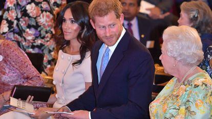 Elizabeth II, o príncipe Harry e Meghan Markle, em uma cerimônia de entrega de prêmios no palácio de Buckingham, em junho de 2018.