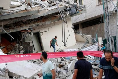 Palestinos vistoriam os escombros de um edifício residencial destruído por um ataque aéreo israelense na Faixa de Gaza.