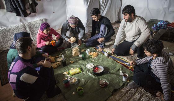 A família yazidi de Arash Faramarzi almoça em sua loja.