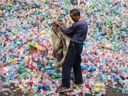 Trabalhador classifica garrafas de plástico para reciclar em Pequim.