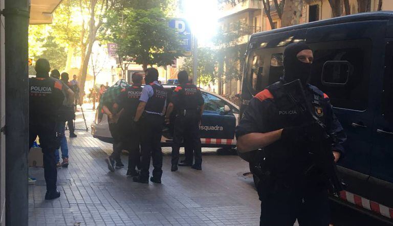 Policiais conduzem um dos detidos, no café Santa Lucía, em Barcelona.