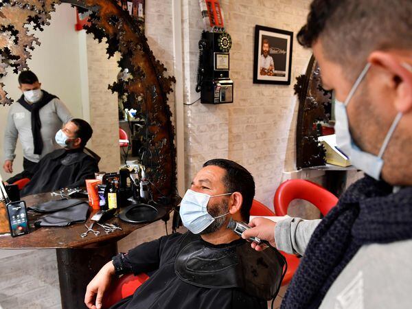 A client wearing a protective face mask gets his beard trimmed at a barber's salon in Bordeaux, southwestern France, on May 11, 2020 on the first day of France's easing of lockdown measures in place for 55 days to curb the spread of the COVID-19 pandemic, caused by the novel coronavirus. (Photo by GEORGES GOBET / AFP)