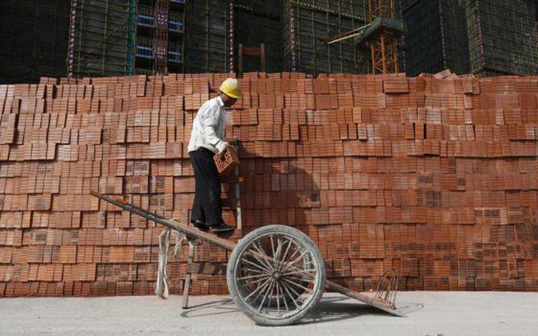 Um operário empilha tijolos na cidade chinesa de Hangzhou.