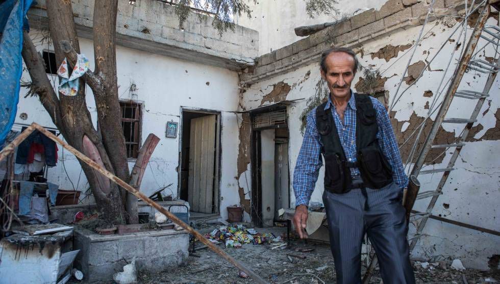 Um membro das forças de segurança curdas inspeciona uma casa bombardeada nesta terça-feira em Qamishli.