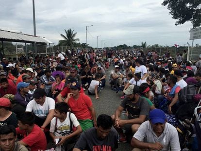 Imigrantes centro-americanos aguardam para entrar no México junto à ponte do rio Suchiate.
