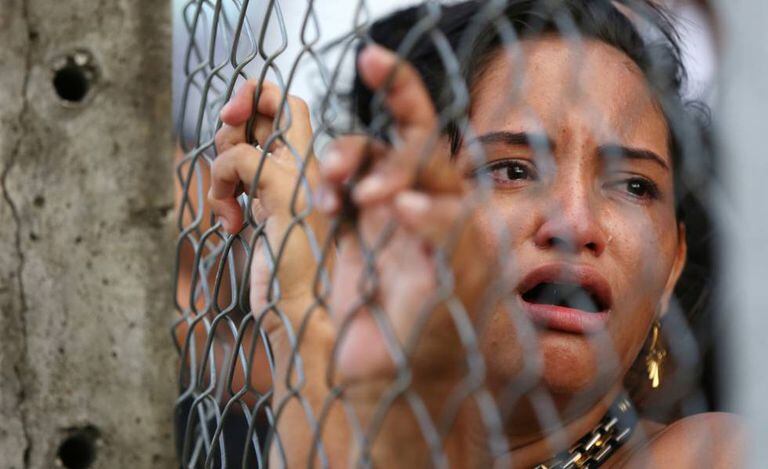 Mulher chora diante com complexo penitenciário em Manaus.