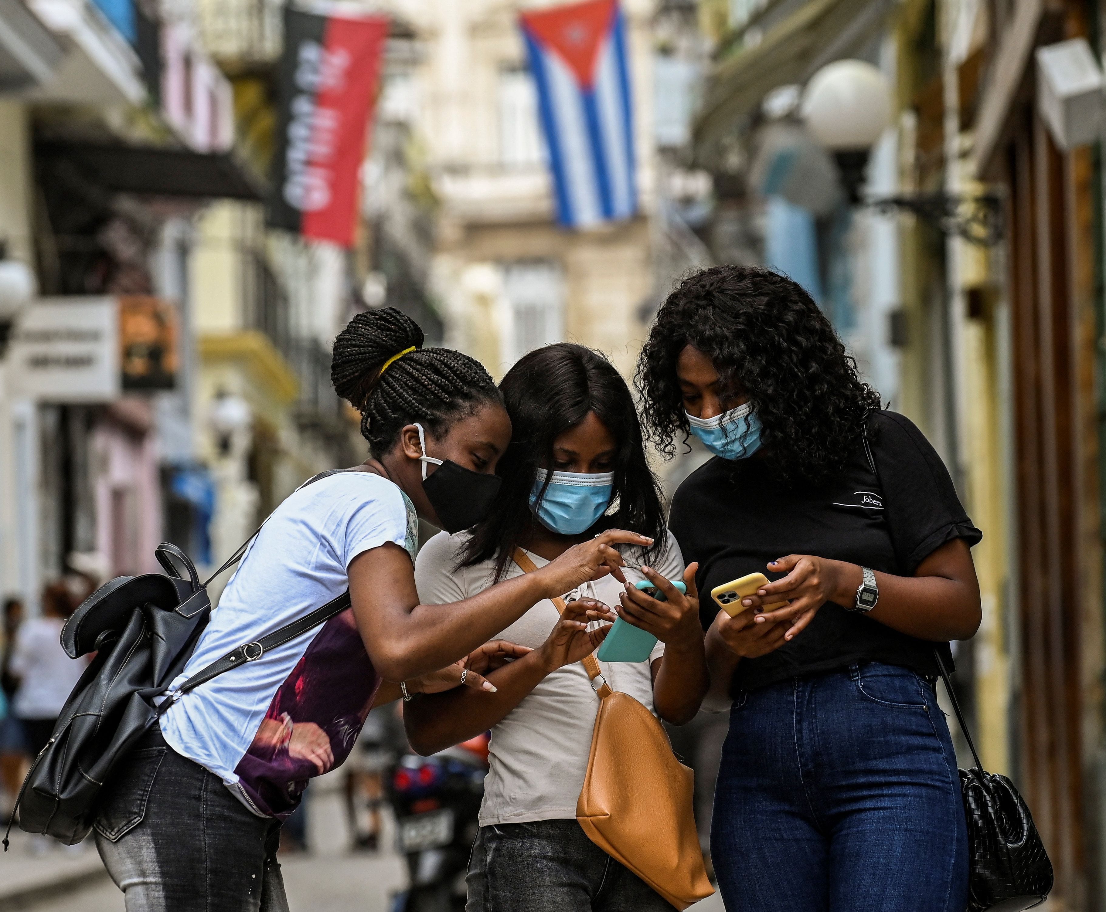 Três mulheres usam seus telefones celulares em Havana, em 14 de julho. 