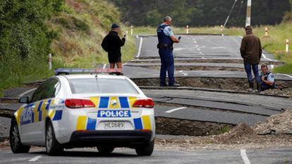 A policial avalia os danos do seísmo em uma estrada de Blenheim, na ilha sul de Nova Zelândia.
