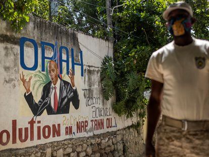 Policial monta guarda em 11 de julho diante de um mural que mostra o presidente haitiano Jovenel Moise na entrada da casa onde foi assassinado, em Porto Príncipe.