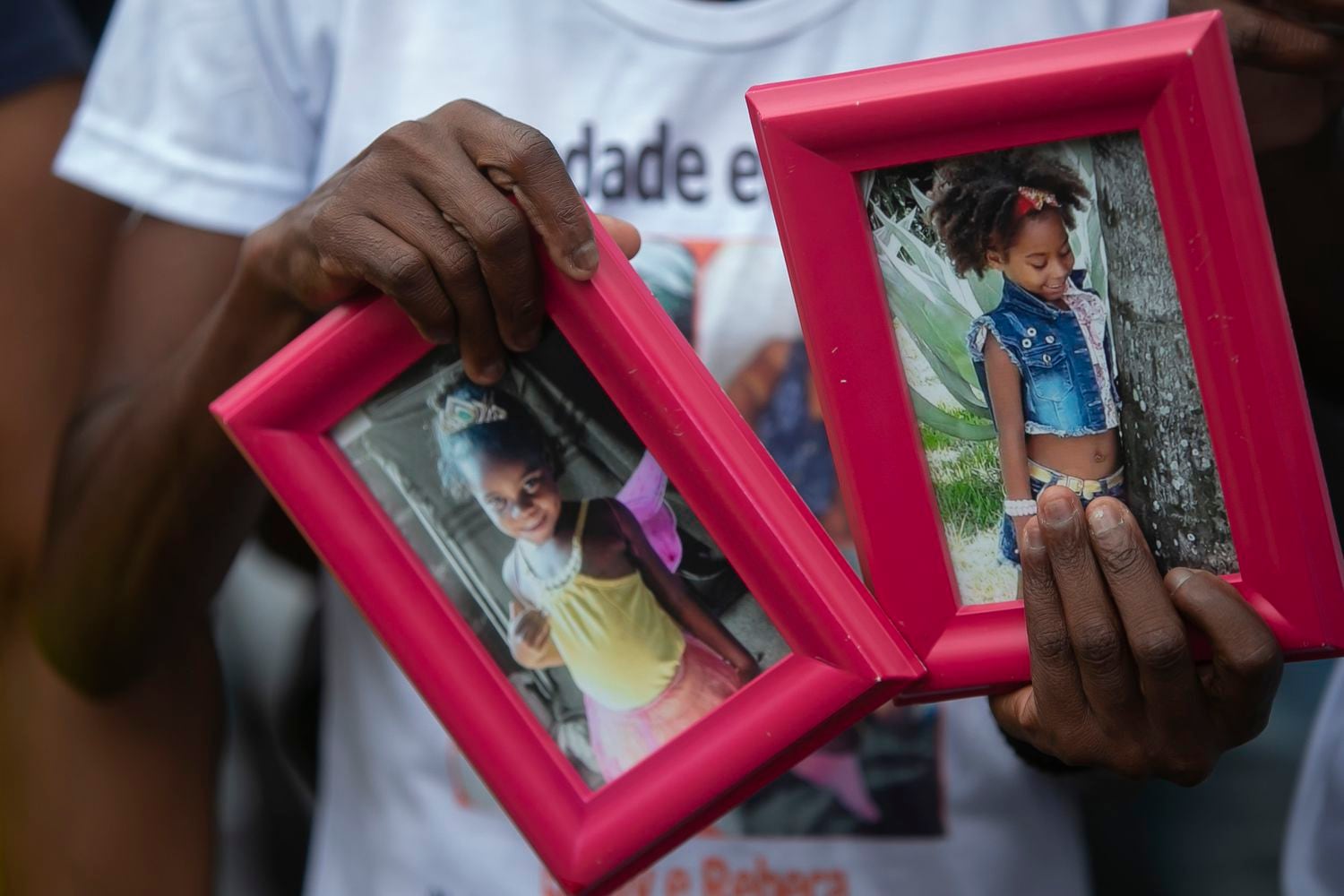 Ana Lúcia Silva Moreira, mãe de Emily Victória, 4, segura as fotos da filha e de sua sobrinha, Rebeca Beatriz, 7, mortas pela polícia.