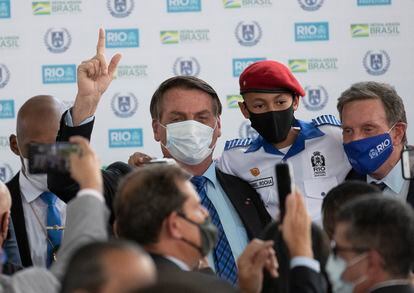 O presidente Jair Bolsonaro, de máscara branca, participa da inauguração de uma escola cívico-militar no Rio de Janeiro em agosto ao lado do prefeito Marcelo Crivella (Republicanos), de máscara azul.