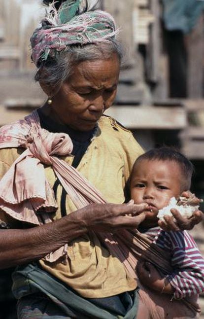 Uma avó alimenta a seu neto com arroz glutinoso, a base da dieta laociana e um alimento muito pobre que afeta o crescimento físico e intelectual.