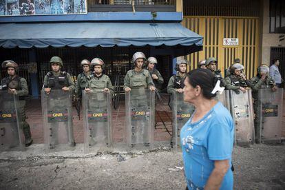 Agentes da Guarda Nacional Bolivariana protegem uma loja em Táchira.