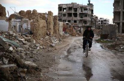 Um sírio anda de bicicleta no bairro de Hazeh, região leste da capital, Damasco.