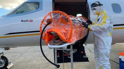 Profissional da saúde prepara maca especial para transporte de paciente com covid-19 em UTI aérea em meio à pandemia no Brasil.