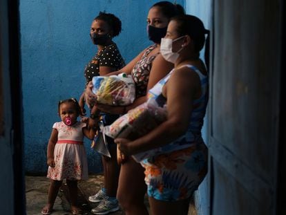 Moradoras de uma favela de Rio de Janeiro, após receber doações em uma escola, em abril.