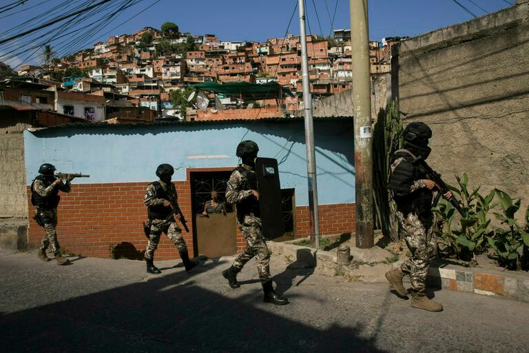 Membros da Polícia Nacional Bolivariana patrulham um bairro de Caracas, Venezuela.
