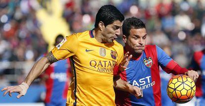 O zagueiro do Levante "Toño" García, à direita, com a bola, ao lado do atacante uruguaio do Barcelona, Luis Suárez.