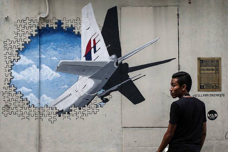 Um homem caminha ao lado de um mural em homenagem ao voo MH370 em Shah Alam, nos arredores de Kuala Lumpur (Malásia), em março de 2015.