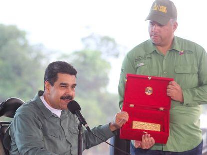 O presidente venezuelano, Nicolás Maduro, mostra um lingote de ouro durante um ato.