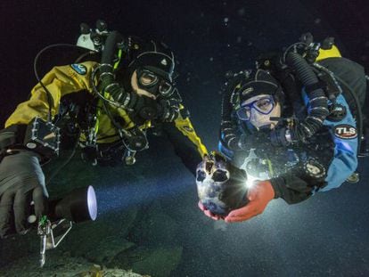 Os mergulhadores Alberto Nava e Susan Bird com o crânio de uma menina de 12.000 anos, descoberto em uma gruta alagada do Yucatán.