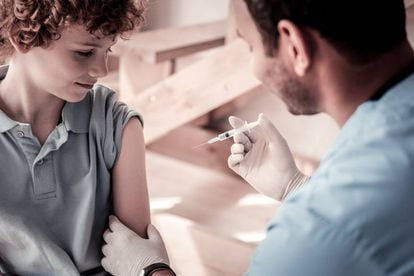 Um médico vacina a uma criança.