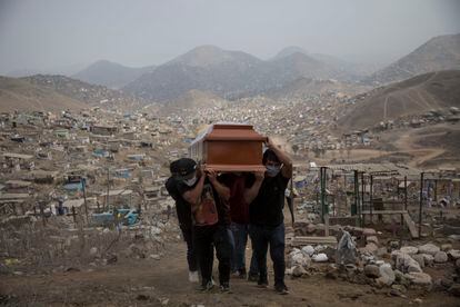 Familiares carregam o caixão de vítima da covid-19 no cemitério Nueva Esperanza, na periferia de Lima, em 2020.