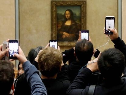 Visitantes do Louvre tiram fotos da ‘Mona Lisa’, em 3 de dezembro.