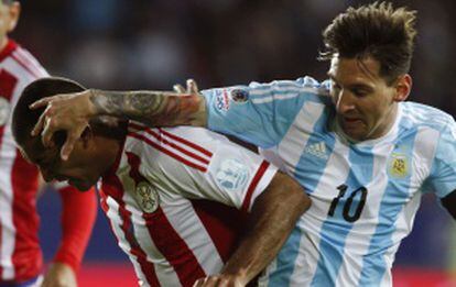 Messi disputa a bola com o paraguaio Da Silva.