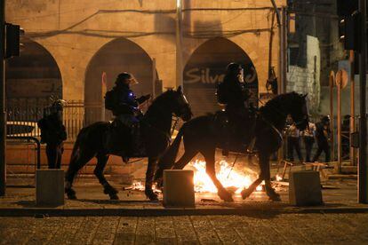 Policiais israelenses a cavalo patrulham os arredores da porta de Damasco, em Jerusalém, durante os distúrbios da noite de quinta-feira.