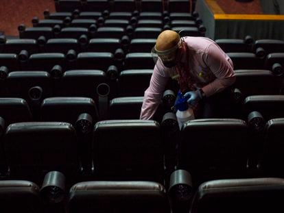 Funcionário limpa os assentos de uma sala de cinema em Caracas, na quarta-feira.