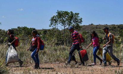 Venezuelanos caminham em Pacaraima, Brasil, depois de cruzar a fronteira.