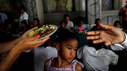 Voluntários distribuem refeições em Caracas, em maio de 2018