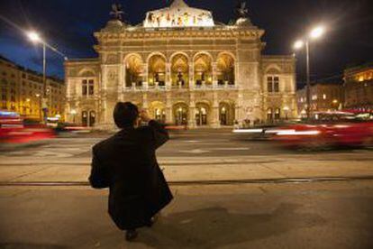Um turista fotografando o edifício da ópera de Viena.