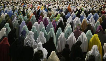 Muçulmanas rezam diante da Grande Mesquita de Meca, em 2009