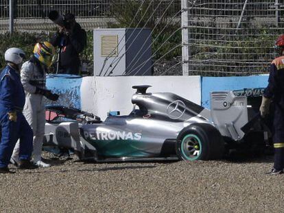 Hamilton observa seu carro após sofrer um acidente.