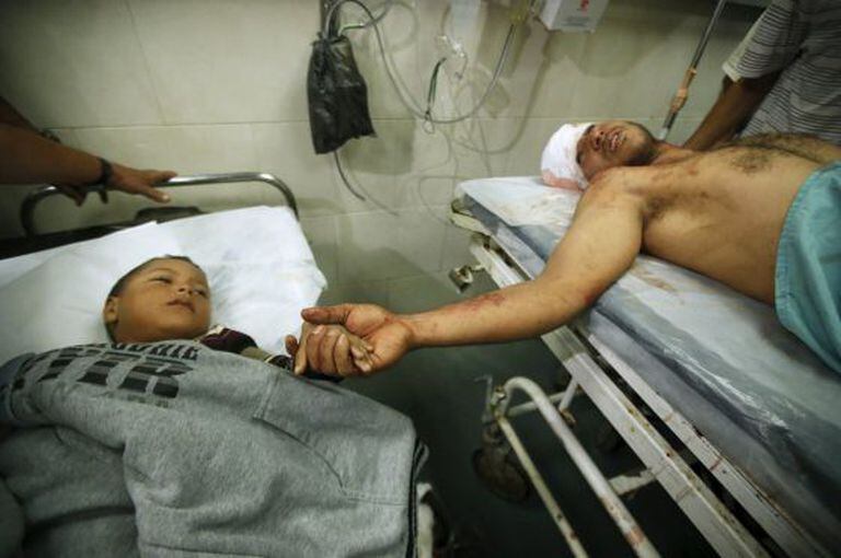 Um pai e um filho hospitalizados depois dos bombardeios israelenses em Gaza.
