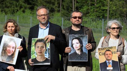 Jornalistas posam na quinta-feira na localidade lituana de Salcininkai com imagens de repórteres bielorrussos detidos.