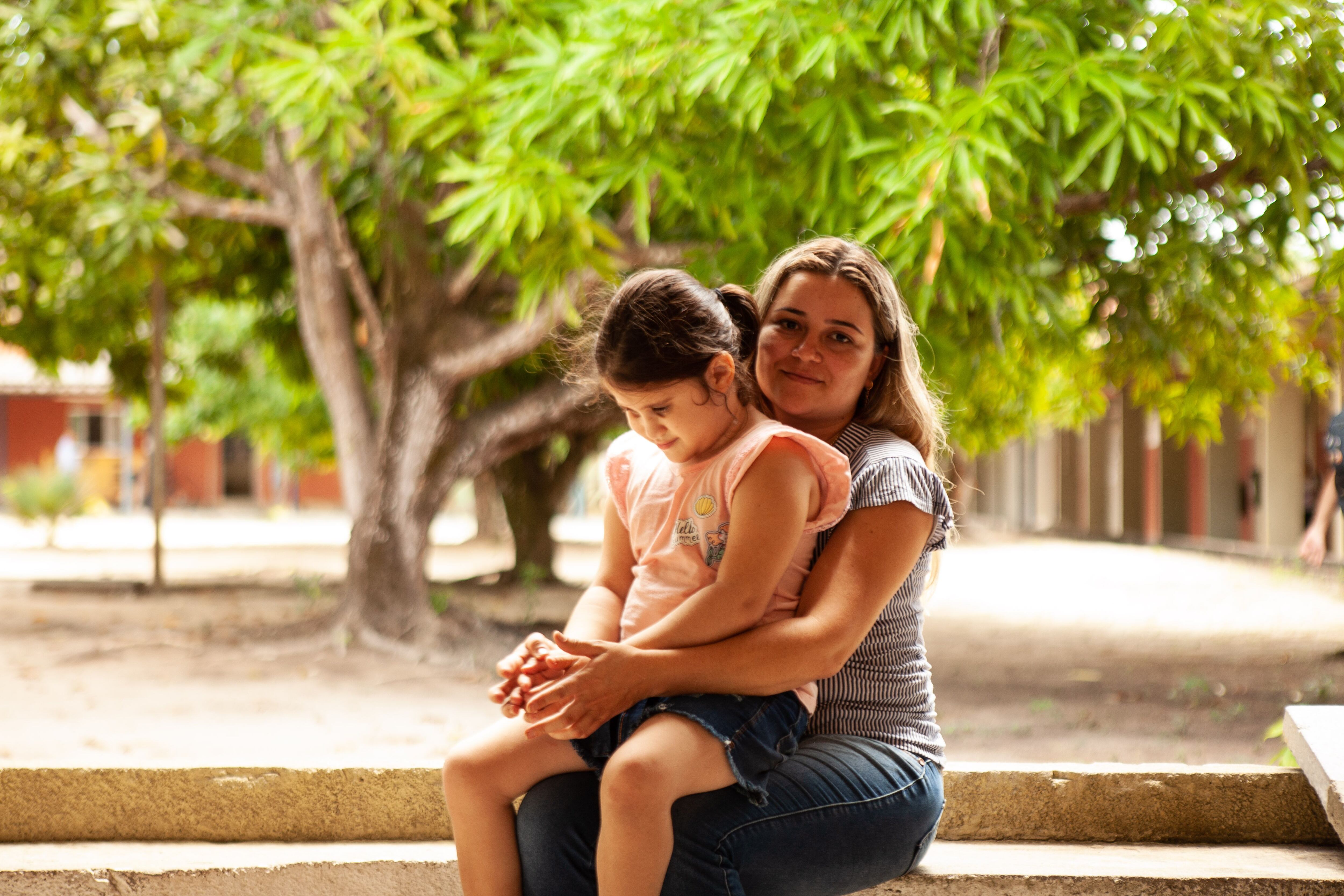 Débora Oliveira e a filha, Nauany Sales, no colo.
