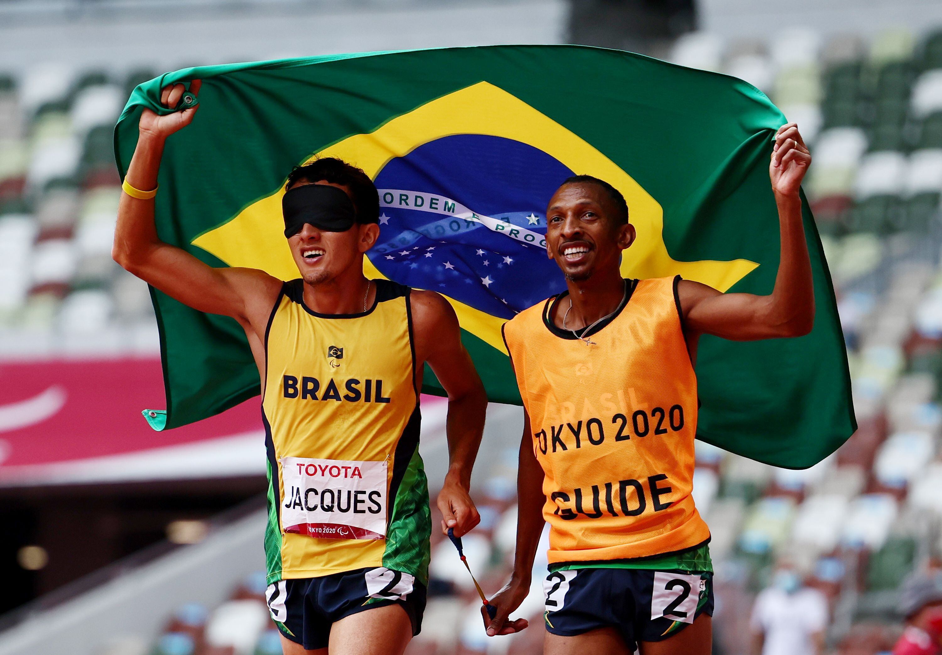 O campeão paralímpico Yeltsin Jacques com o atleta-guia Carlos Antonio dos Santos celebram a segunda medalha de ouro do corredor nos Jogos Paralímpicos de Tóquio.