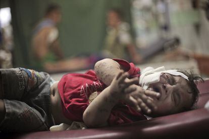 Uma criança ferida no ataque à escola da ONU em 30 de julho de 2014, chora enquanto é atendida em um hospital.