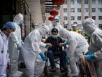 TOPSHOT - This photo taken on June 17, 2020 shows medical workers carrying a man who is the last patient recovered from the COVID-19 coronavirus infection in the Wuhan, pulmonary hospital before he leaves the hospital in Wuhan, in China's central Hubei province. (Photo by STR / AFP) / China OUT