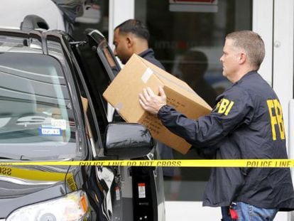 Agentes do FBI saem com caixas da sede da Imagina, em Miami.