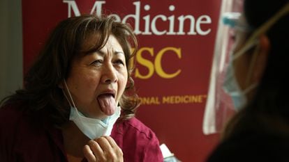 Uma mulher mostra a língua para uma enfermeira em Los Angeles, na Califórnia, em 23 de janeiro de 2021