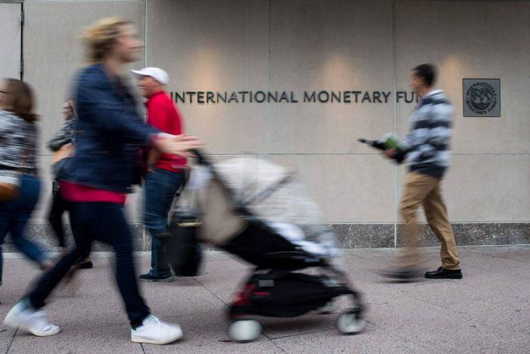 Transeúntes passam em frente à sede do FMI em Washington.
