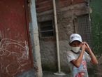 A child adjusts a facemask at the city's biggest slum Paraisopolis after residents have hired a round-the-clock private medical service to fight the coronavirus disease (COVID-19), in Sao Paulo, Brazil March 30, 2020. Picture taken March 30, 2020. REUTERS/Amanda Perobelli