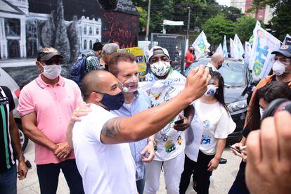 Celso Russomano cercado de apoiadores durante evento de campanha, em São Paulo.